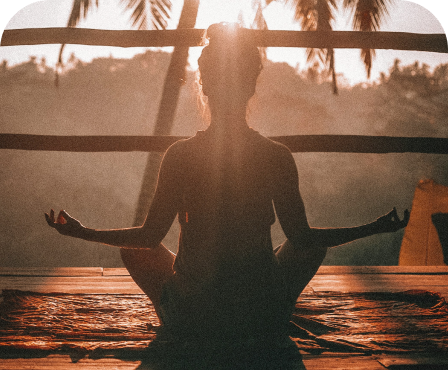 Silhouette of person in meditation pose at sunset, representing hormonal balance and wellness